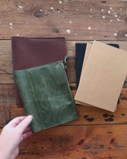 Video of the Curator's Companion set's parts on a timber bench: a brown leather Curator cover, a green Companion organiser and kraft notebooks
